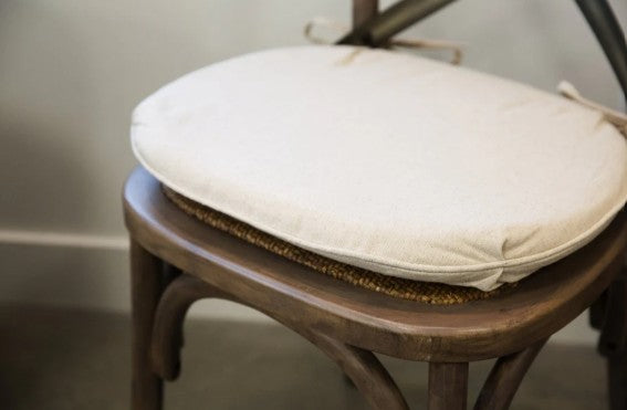 Wooden chair with a white cushion on a plain background