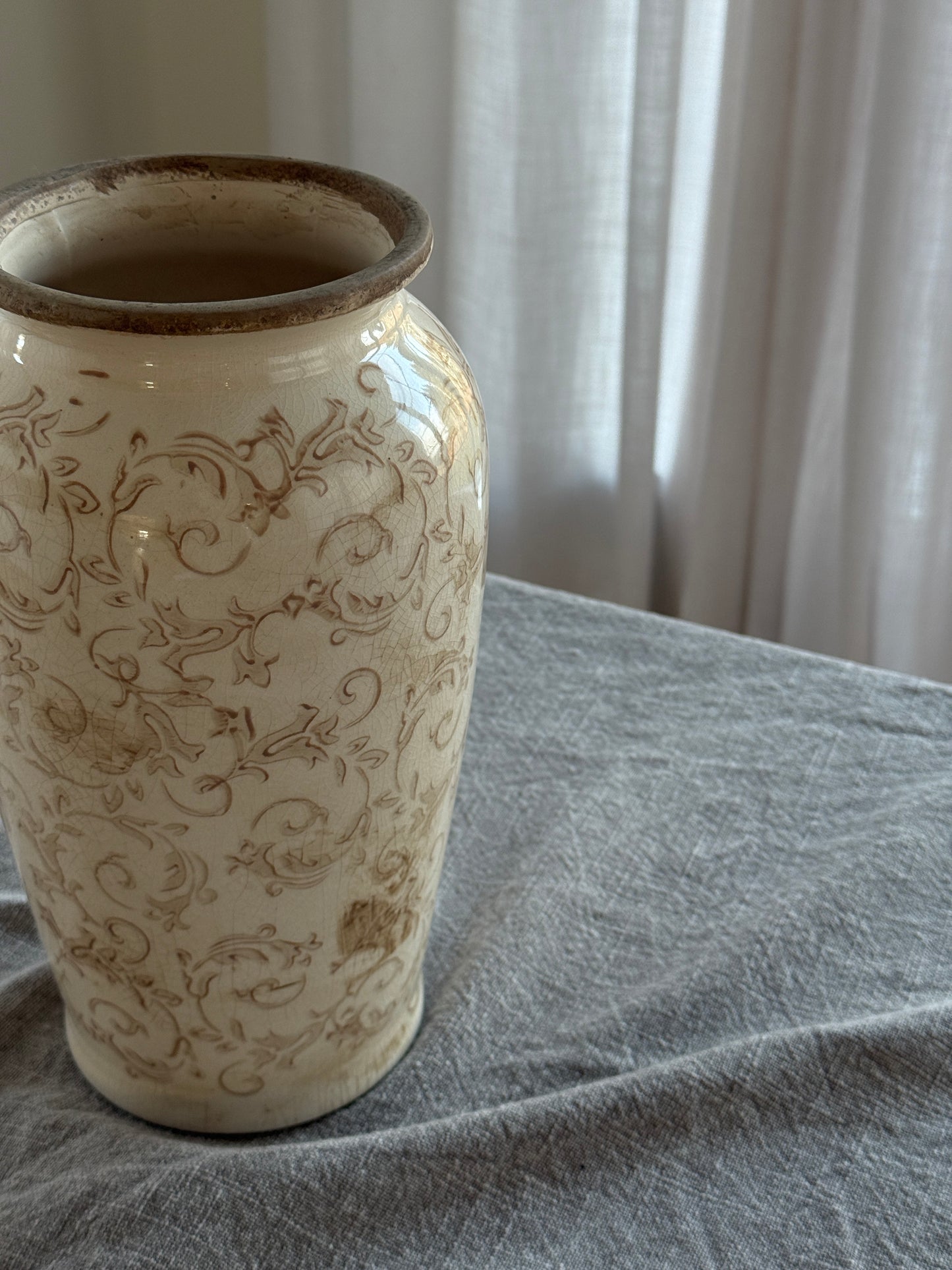 Decorative ceramic vase with intricate patterns on a textured surface