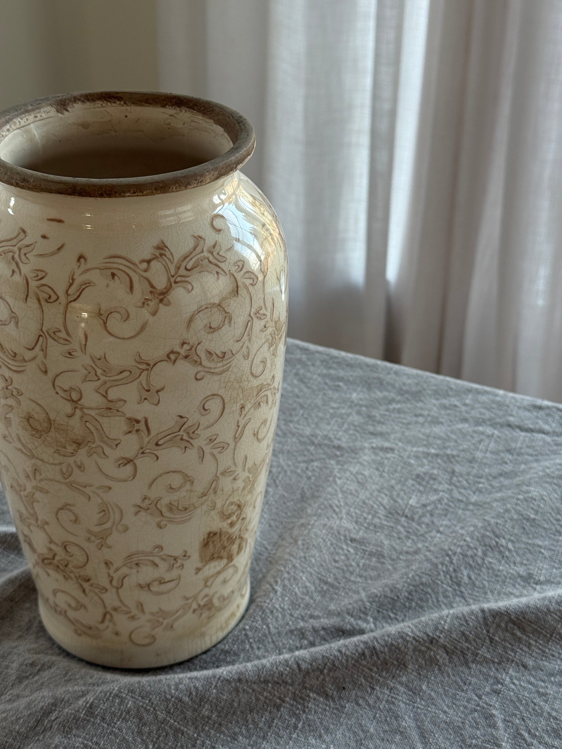 Decorative ceramic vase with intricate patterns on a textured surface