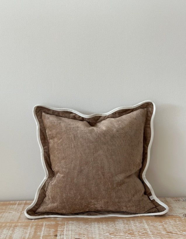 Brown pillow with white trim