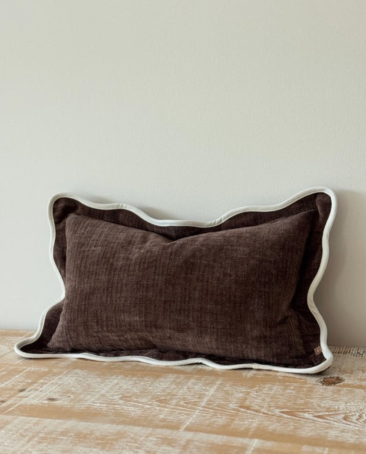 Brown lumbar pillow with white trim