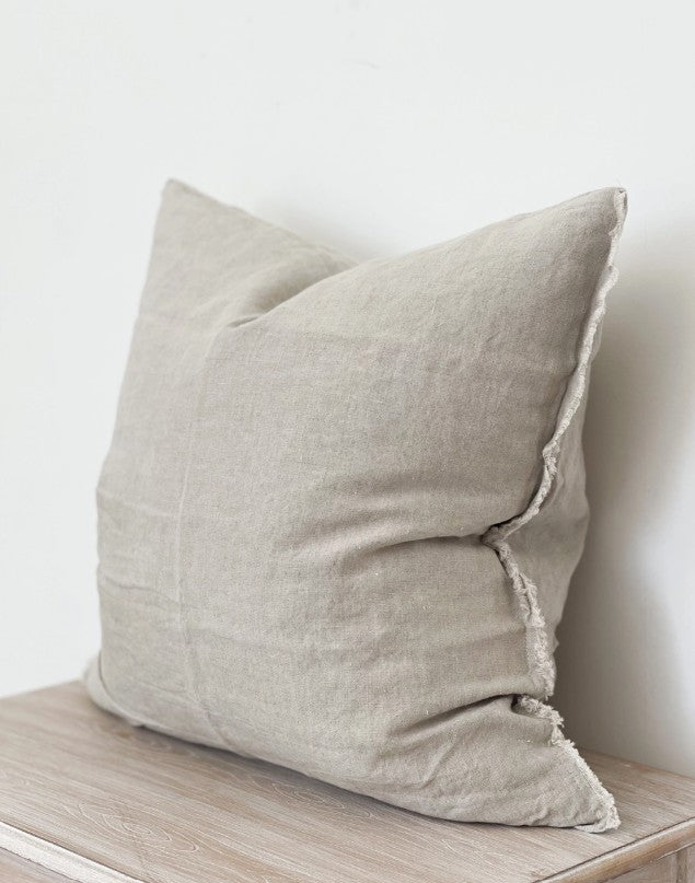 Beige pillow on a wooden surface with a white background