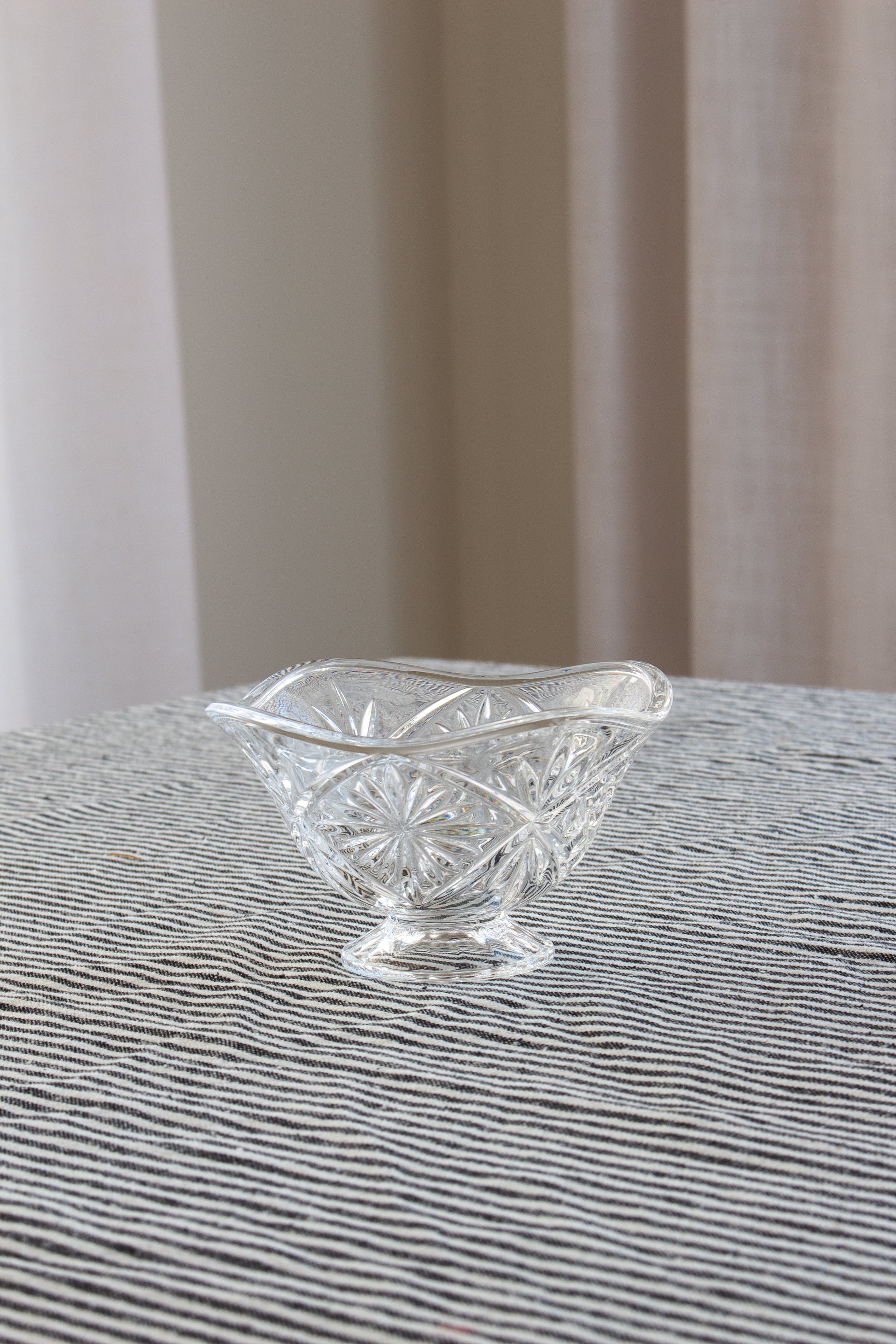Clear glass bowl on a textured surface with a neutral background