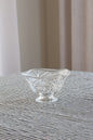Clear glass bowl on a textured surface with a neutral background