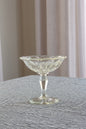 Clear glass compote on a textured surface with a neutral background