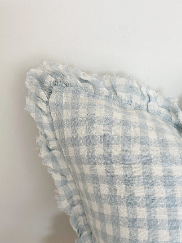 Blue and white checkered fabric with ruffled edges on a light background