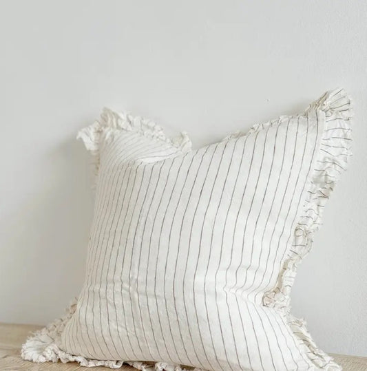 Decorative pillow with ruffled edges on a neutral background