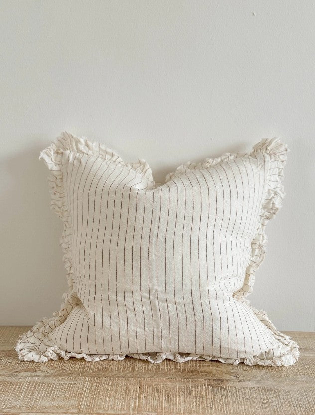 Textured pillow with ruffled edges on a neutral background
