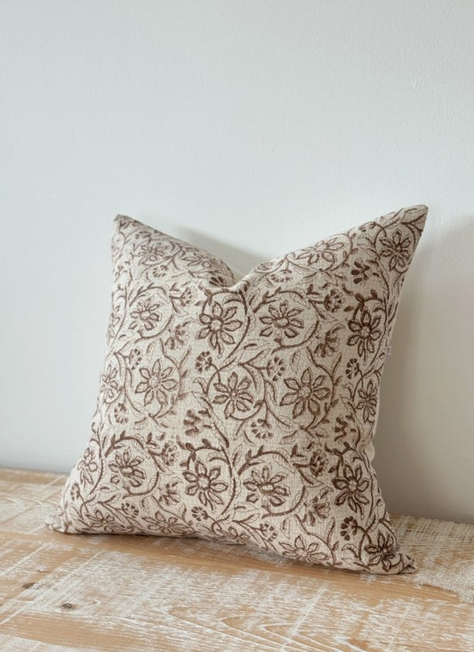 Decorative pillow with floral pattern on a wooden surface