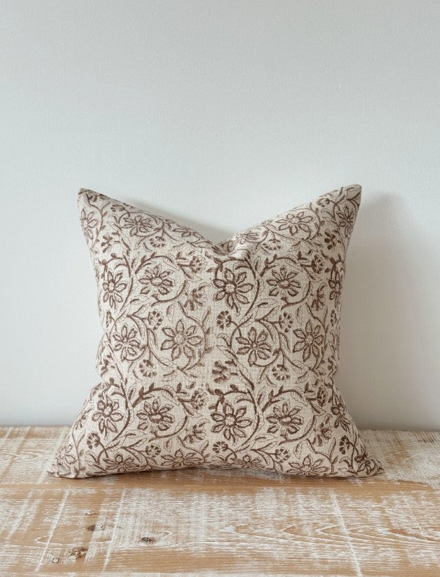 Decorative pillow with floral pattern on a wooden surface