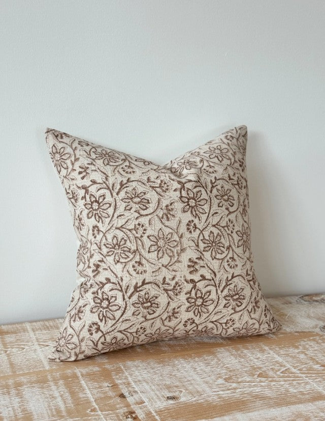 Decorative pillow with floral pattern on a wooden surface