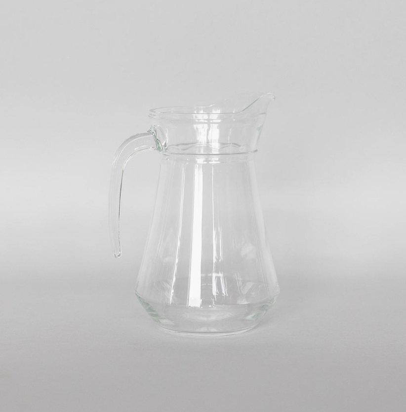 Clear glass pitcher on a light gray background