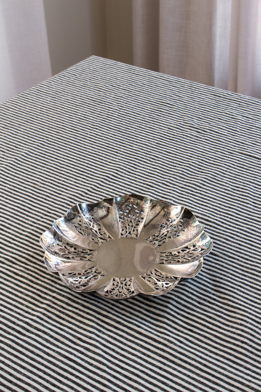 Silver decorative bowl on a striped fabric surface
