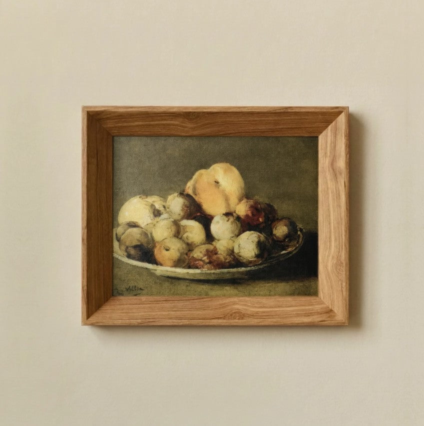 Framed still life painting of apples on a plate against a beige wall
