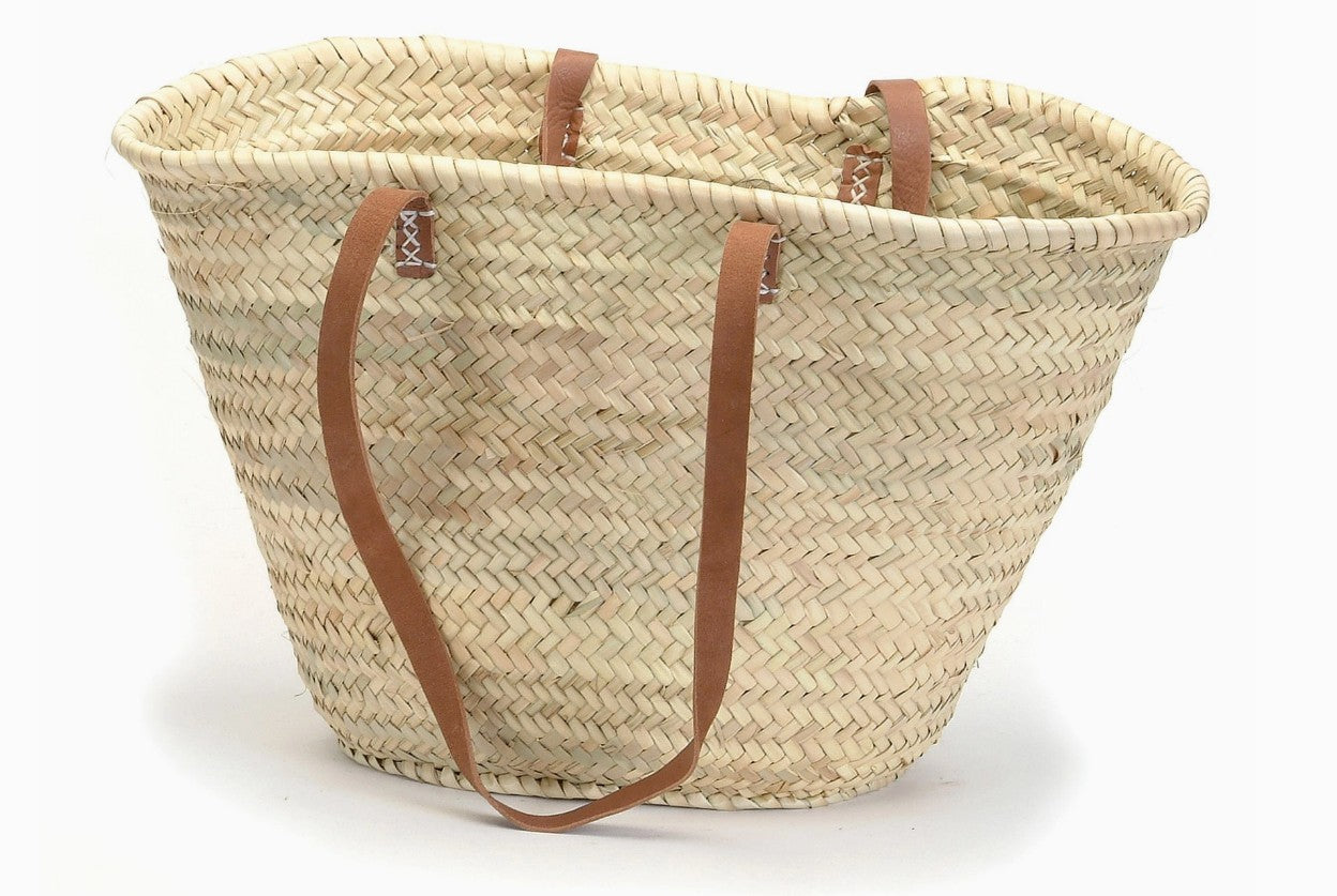 Woven market bag with brown handles on a white background