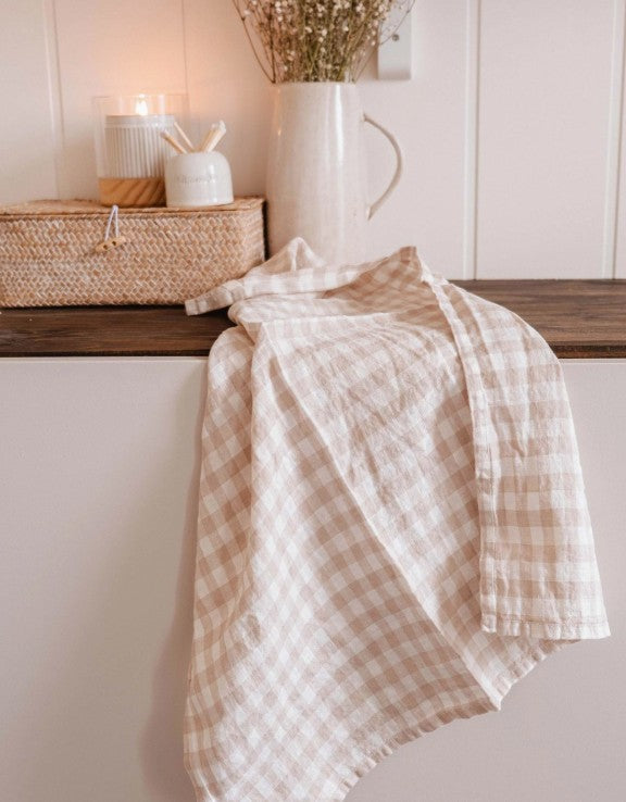 Plaid towel draped over a wooden surface with decorative items in the background