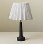 Table lamp with a black base and white lampshade on a beige background
